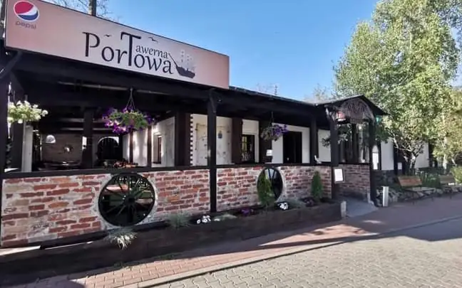 Drewniana elewacja Tawerny Portowej z napisem nad wejściem