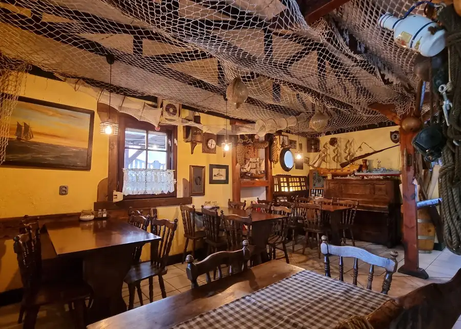 Sala z drewnianymi belkami i sieciami pod sufitem